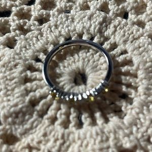 Sterling silver ring with clear and yellow stones on the front half.